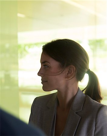 simsearch:6113-06909277,k - Profile brunette businesswoman listening, looking away Stock Photo - Premium Royalty-Free, Code: 6113-09058860