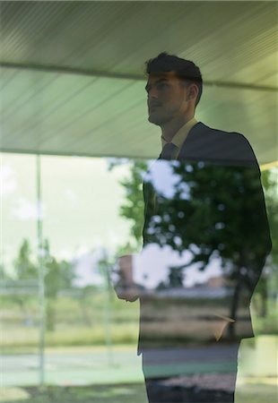 simsearch:6113-06909277,k - Pensive businessman looking out office window Stock Photo - Premium Royalty-Free, Code: 6113-09058956