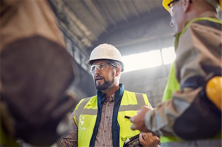 simsearch:6113-08655293,k - Supervisor talking to steelworkers in steel mill Stock Photo - Premium Royalty-Free, Code: 6113-09059053
