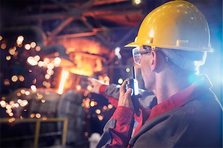 foundry worker - Steelworker talking, using walkie-talkie in steel mill Stock Photo - Premium Royalty-Free, Code: 6113-09059073