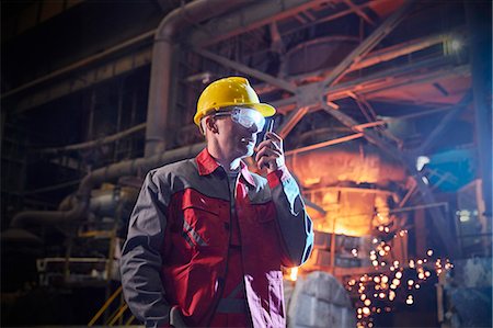 foundry worker - Steelworker talking, using walkie-talkie in steel mill Stock Photo - Premium Royalty-Free, Code: 6113-09059084