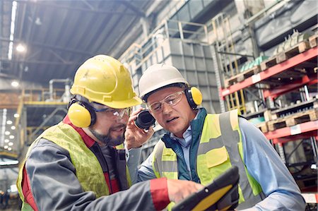 Steelworkers wearing ear protectors using digital tablet in steel mill Stock Photo - Premium Royalty-Free, Code: 6113-09059091