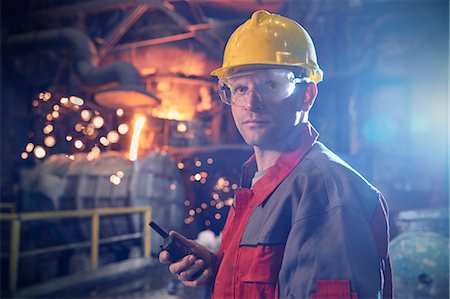 Portrait confident, serious steelworker with walkie-talkie in steel mill Foto de stock - Sin royalties Premium, Código: 6113-09059018