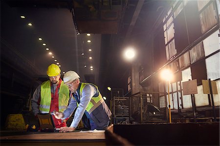 Steelworkers using laptop in steel mill Stock Photo - Premium Royalty-Free, Code: 6113-09059032