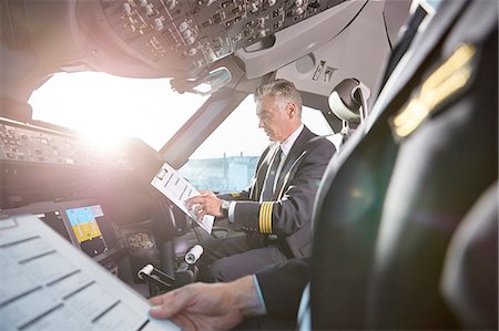 pilot - Male pilots with clipboard preparing in airplane cockpit Stock Photo - Premium Royalty-Free, Code: 6113-09059124