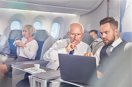 seated on airplane - Businessmen working at laptop in first class on airplane Stock Photo - Premium Royalty-Free, Code: 6113-09059202