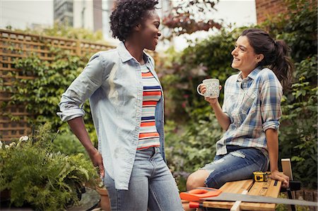 Women drinking coffee and talking, doing project on patio Stock Photo - Premium Royalty-Free, Code: 6113-09059328