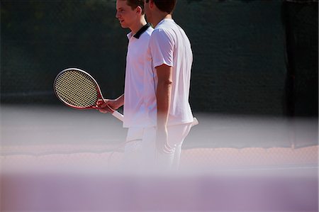 Male tennis doubles talking on sunny tennis court Stock Photo - Premium Royalty-Free, Code: 6113-09005056