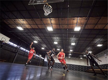 recreational pursuit - Young male basketball players playing basketball on court in gym Stock Photo - Premium Royalty-Free, Code: 6113-09005142