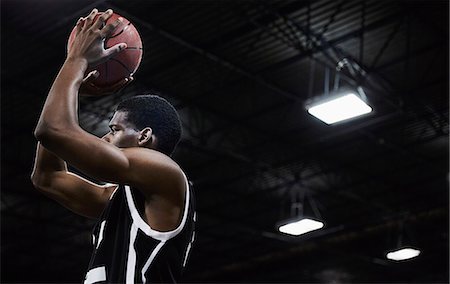 sports jersey - Focused young male basketball player shooting the ball in gymnasium Stock Photo - Premium Royalty-Free, Code: 6113-09005121