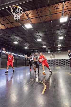 simsearch:6113-08698170,k - Young male basketball players playing basketball on court in gymnasium Stock Photo - Premium Royalty-Free, Code: 6113-09005128