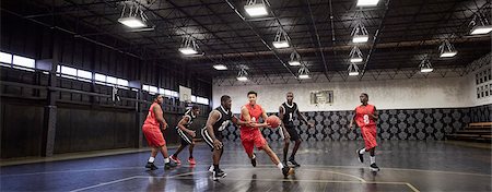 simsearch:6113-07730460,k - Young male basketball players playing game on court in gymnasium Stock Photo - Premium Royalty-Free, Code: 6113-09005136