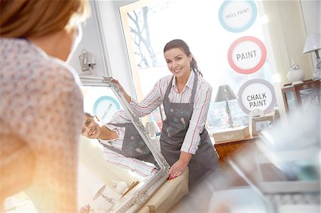 simsearch:6118-08202525,k - Smiling female artists moving painted mirror in art class workshop Stock Photo - Premium Royalty-Free, Code: 6113-09005275