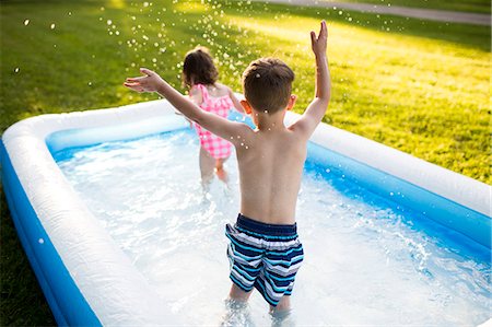 simsearch:700-00280017,k - Preschool brother and sister playing and splashing in inflatable swimming pool Stock Photo - Premium Royalty-Free, Code: 6113-09005365