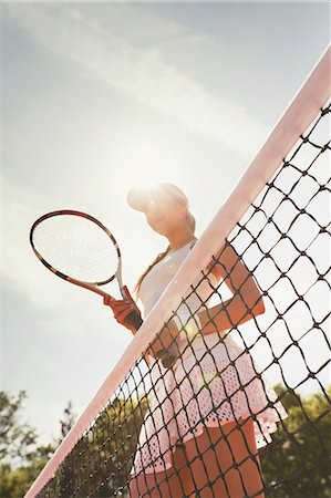 simsearch:858-05604961,k - Focused female tennis player with tennis racket standing at net on sunny tennis court Photographie de stock - Premium Libres de Droits, Code: 6113-09005388