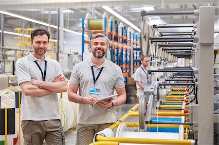 fiber optic - Portrait smiling, confident male workers with digital tablet on fiber optics factory floor Stock Photo - Premium Royalty-Free, Code: 6113-09005313