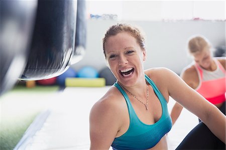 Portrait laughing female boxer stretching in gym Stock Photo - Premium Royalty-Free, Code: 6113-09027361