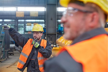 Male foreman using walkie-talkie in factory Stock Photo - Premium Royalty-Free, Code: 6113-09027473