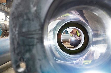 simsearch:6113-08393850,k - Male engineer with flashlight examining steel pipe in factory Photographie de stock - Premium Libres de Droits, Code: 6113-09027482