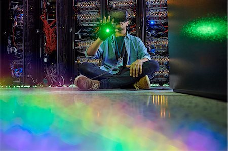 Male computer programmer using virtual reality simulator glasses in dark server room Stock Photo - Premium Royalty-Free, Code: 6113-09027567