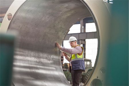 simsearch:6113-08393850,k - Male engineer examining large steel cylinder in factory Photographie de stock - Premium Libres de Droits, Code: 6113-09027524