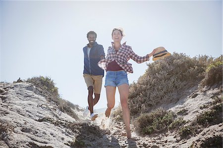 simsearch:632-05845211,k - Playful, energetic multi-ethnic couple running on sunny summer sand beach path Stock Photo - Premium Royalty-Free, Code: 6113-09027650