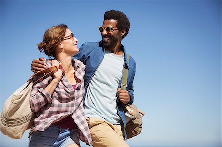 simsearch:700-03503010,k - Affectionate multi-ethnic couple hugging and walking below sunny summer blue sky Stock Photo - Premium Royalty-Free, Code: 6113-09027675