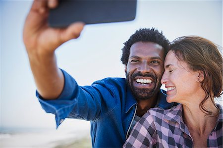 simsearch:632-05845211,k - Affectionate, happy multi-ethnic couple taking selfie with camera phone Stock Photo - Premium Royalty-Free, Code: 6113-09027745