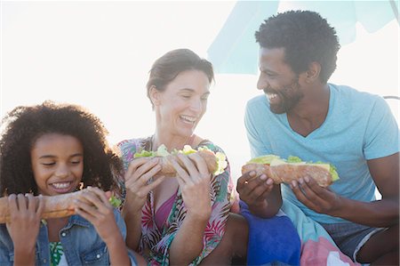 Multi-ethnic family eating baguette sandwiches Stock Photo - Premium Royalty-Free, Code: 6113-09027750