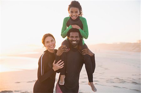 simsearch:632-05845211,k - Portrait smiling, happy family in wet suits on sunny summer beach Stock Photo - Premium Royalty-Free, Code: 6113-09027778