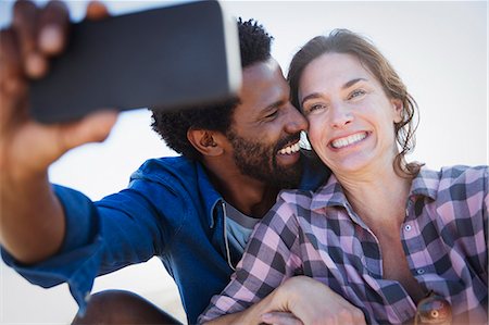 simsearch:6113-07565751,k - Smiling, enthusiastic multi-ethnic couple taking selfie with camera phone Stock Photo - Premium Royalty-Free, Code: 6113-09027701