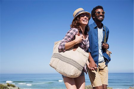 simsearch:6113-07589470,k - Smiling, affectionate couple holding hands on sunny summer ocean beach Stock Photo - Premium Royalty-Free, Code: 6113-09027707
