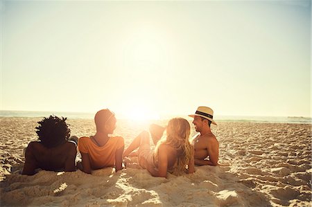 simsearch:6113-07147024,k - Young couples laying, relaxing on sunny summer beach Stock Photo - Premium Royalty-Free, Code: 6113-09027842