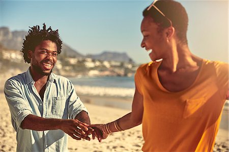 simsearch:6113-07589470,k - Playful young couple holding hands on sunny summer beach Stock Photo - Premium Royalty-Free, Code: 6113-09027853