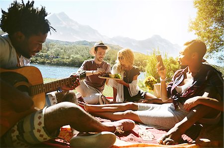 simsearch:614-06719795,k - Young friends hanging out, playing guitar and enjoying picnic at sunny summer riverside Stock Photo - Premium Royalty-Free, Code: 6113-09027867