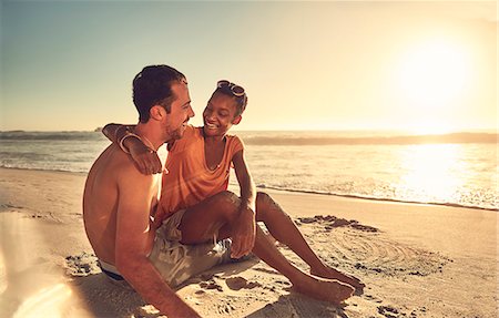 simsearch:6113-07147024,k - Affectionate young couple hugging on sunny summer ocean beach Stock Photo - Premium Royalty-Free, Code: 6113-09027886