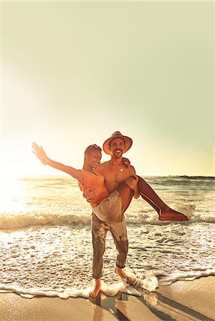 simsearch:6113-07147024,k - Portrait playful young couple on sunny summer ocean beach Stock Photo - Premium Royalty-Free, Code: 6113-09027916