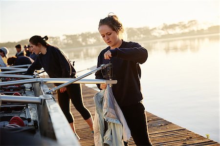 simsearch:700-01633002,k - Female rowers preparing scull on sunny lakeside dock Stock Photo - Premium Royalty-Free, Code: 6113-09144527