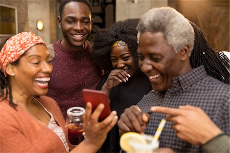 Happy multi-generation family laughing, using smart phone Stock Photo - Premium Royalty-Free, Code: 6113-09144656