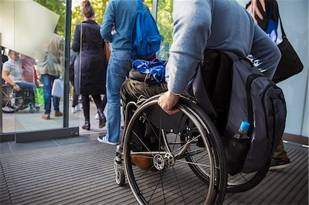 Man in wheelchair leaving office Stock Photo - Premium Royalty-Free, Code: 6113-09157356