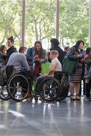 simsearch:700-03178533,k - Business people in wheelchairs talking in lobby at conference Photographie de stock - Premium Libres de Droits, Code: 6113-09157412