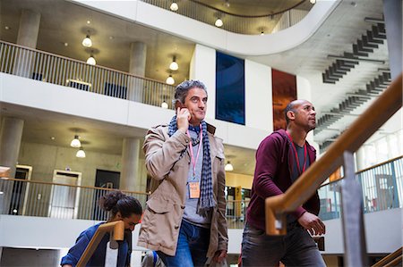 simsearch:649-07520071,k - Businessman talking on cell phone, ascending office stairs Stock Photo - Premium Royalty-Free, Code: 6113-09157415