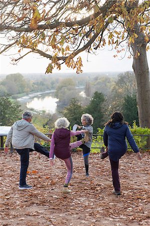 simsearch:693-06018275,k - Active seniors stretching, exercising in autumn park Stock Photo - Premium Royalty-Free, Code: 6113-09157576