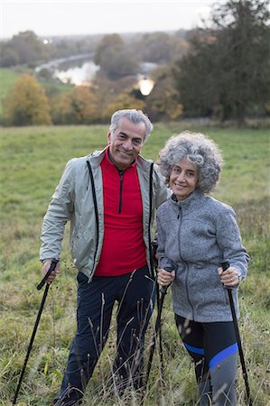 simsearch:6113-07589442,k - Portrait confident active senior couple hiking with poles in rural field Stock Photo - Premium Royalty-Free, Code: 6113-09157594