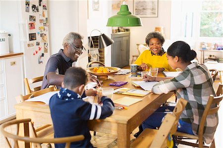 simsearch:6113-07565586,k - Grandparents at dining table with grandchildren doing homework Stock Photo - Premium Royalty-Free, Code: 6113-09157663