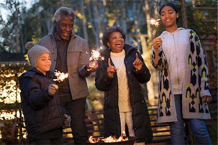 simsearch:6113-07565586,k - Grandparents and grandchildren playing with firework sparklers Stock Photo - Premium Royalty-Free, Code: 6113-09157673