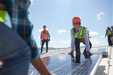 simsearch:6108-06168107,k - Engineers lifting solar panel at sunny power plant Stock Photo - Premium Royalty-Free, Code: 6113-09157795