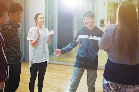 simsearch:649-07063753,k - Classmates clapping for teenage boy in dance class studio Stock Photo - Premium Royalty-Free, Code: 6113-09157896