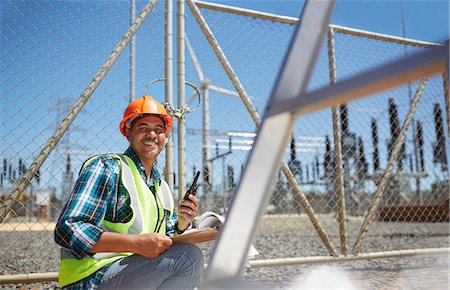 simsearch:6113-07160283,k - Portrait smiling, confident male engineer with walkie-talkie at power plant Stock Photo - Premium Royalty-Free, Code: 6113-09157804