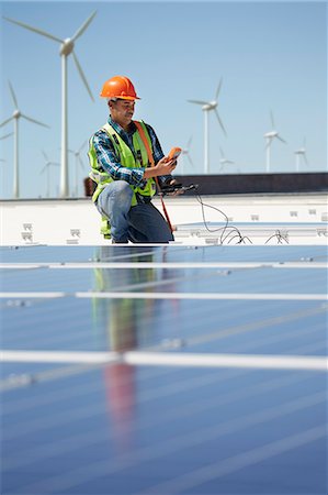 simsearch:6108-06168107,k - Engineer with equipment inspecting solar panels at sunny power plant Stock Photo - Premium Royalty-Free, Code: 6113-09157811